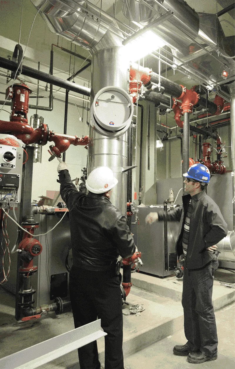 BMI technicians isolating a valve in a condominium mechanical room during an after-hours callout