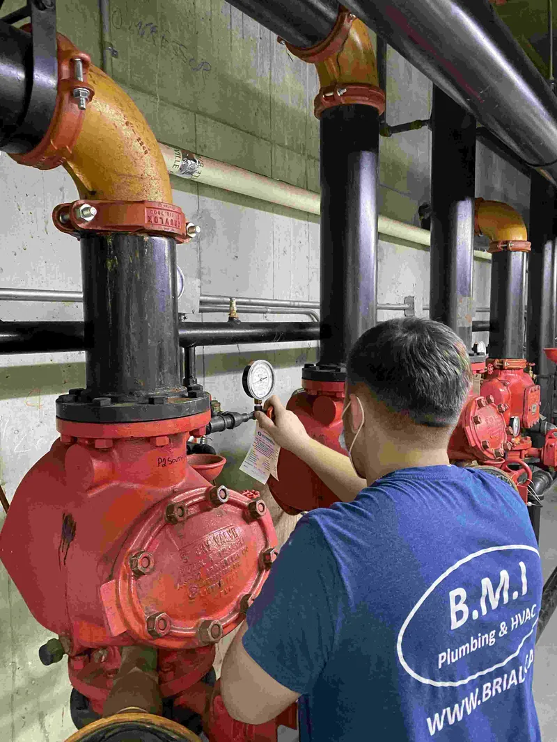 BMI technician taking a pressure reading at a valve station in a Toronto condominium mechanical room