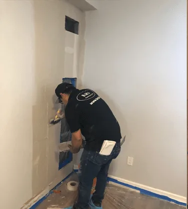 BMI finishing crew closing and taping the drywall over a replaced condominium riser