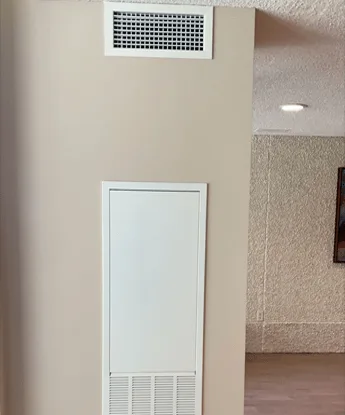 Finished and painted suite wall with a new access panel after BMI riser replacement